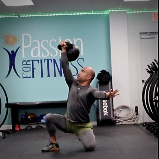 Man performing kettlebell Turkish get-up at Passion for Fitness gym in Exton